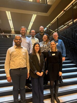 Eight people standing on a staircase.